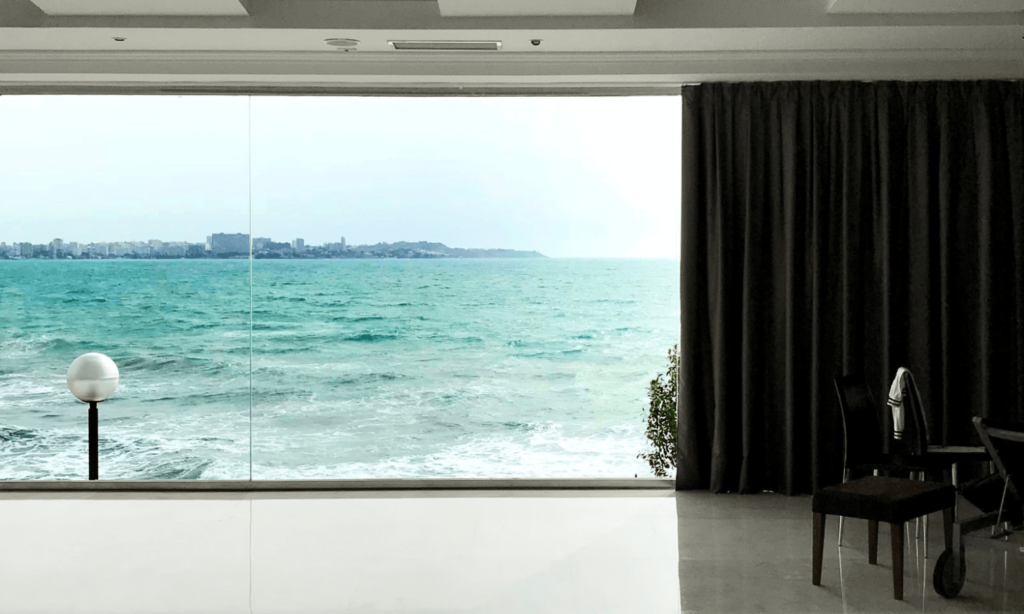 sala de estar com envidraçamento e vista para o mar