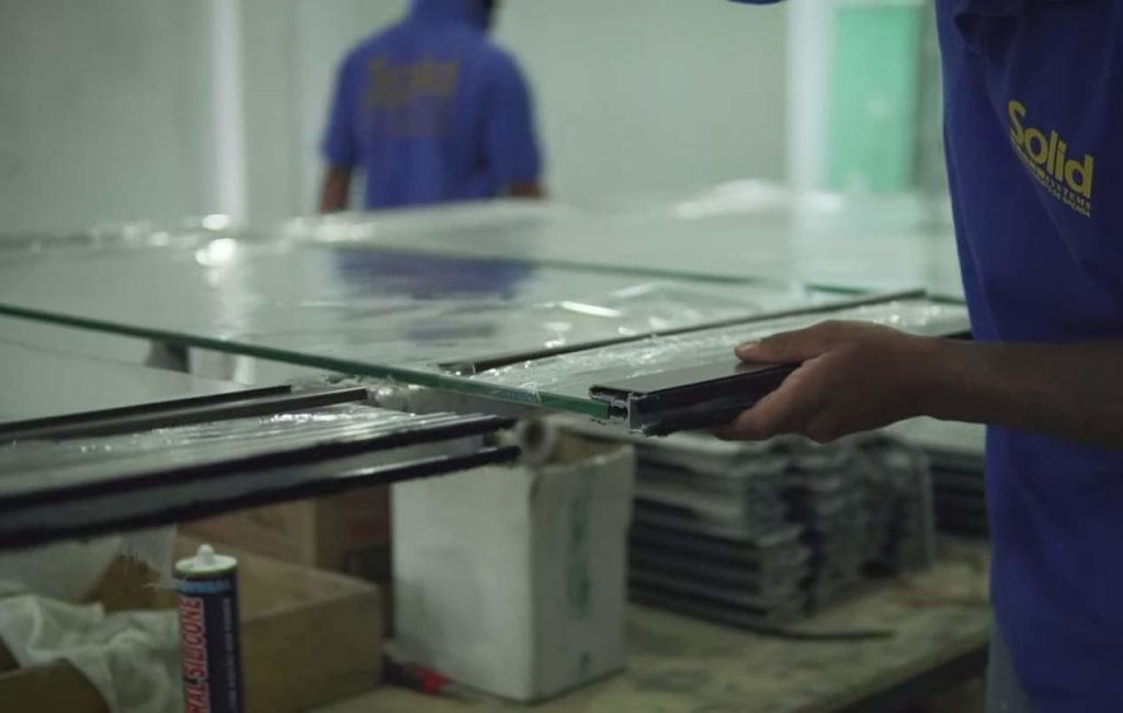 Fábrica Solid Systems, funcionário manuseando vidro